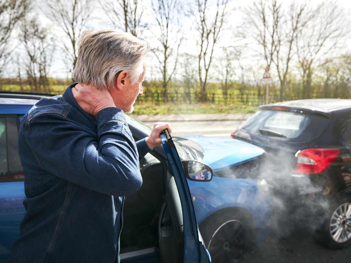man in an auto accident holding his neck from an auto injury