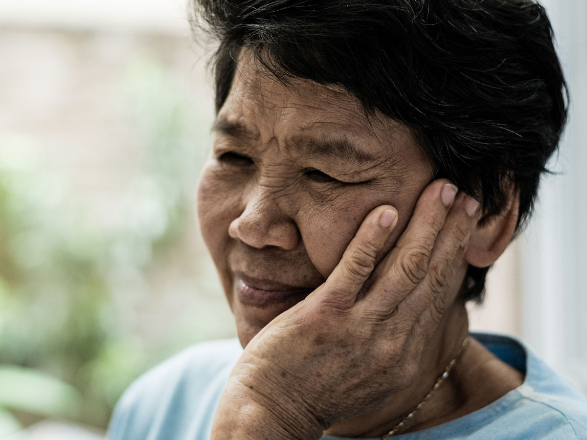 elderly woman suffering from tmj pain